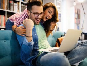 Couple playing online escape room with laptop